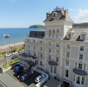 Image of exterior of St George's Hotel with sea in background